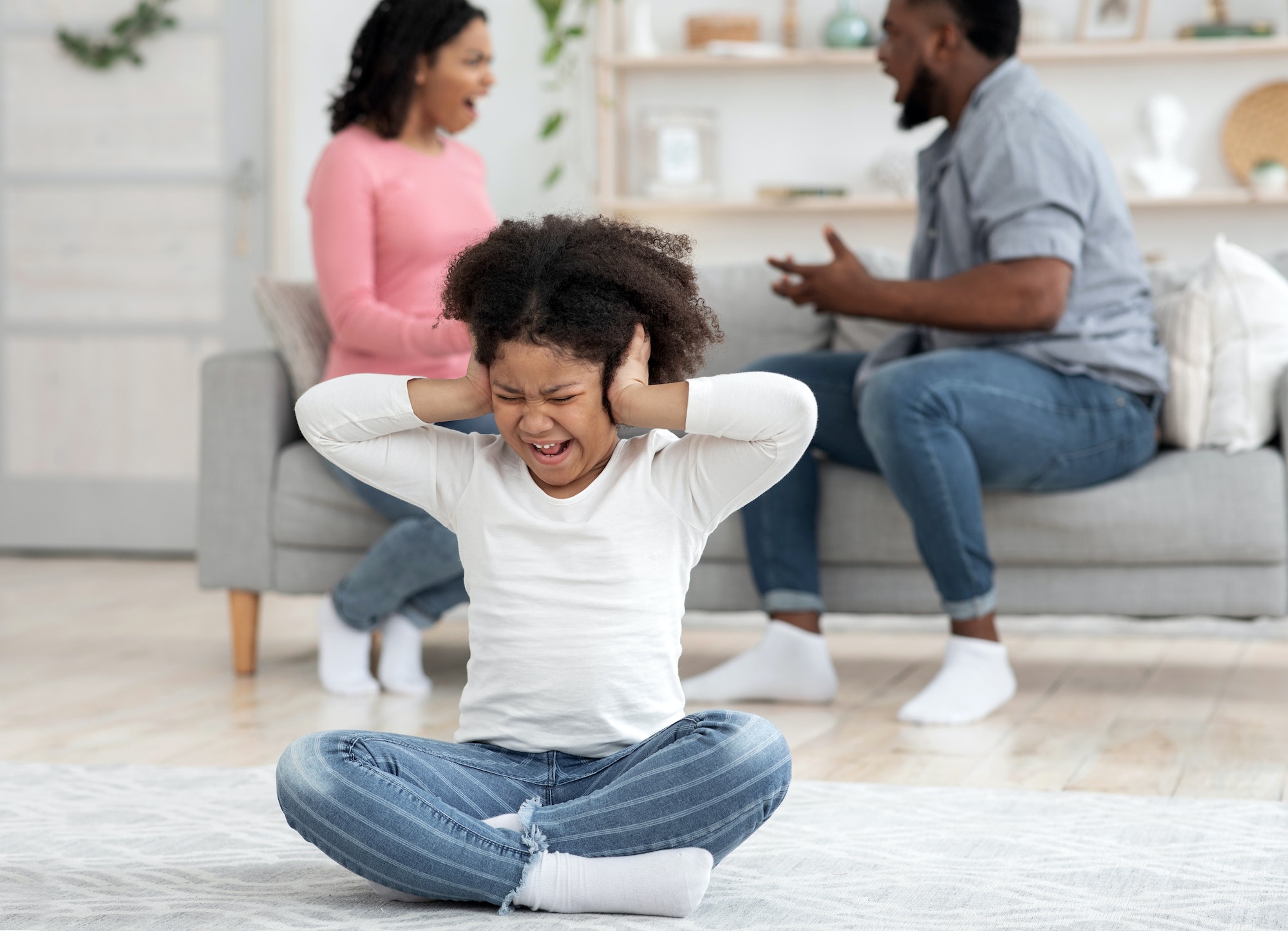 Childhood Traumas. Little Black Girl Covering Ears Not To Hear Parents Quarrels