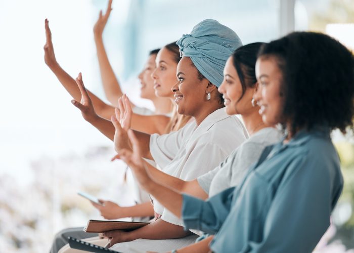 Business women question hands raised in diversity, inclusion and empowerment workshop training or t